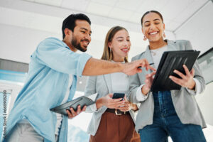 Trio de personnes qui sourient face à une tablette, semaine du Digital